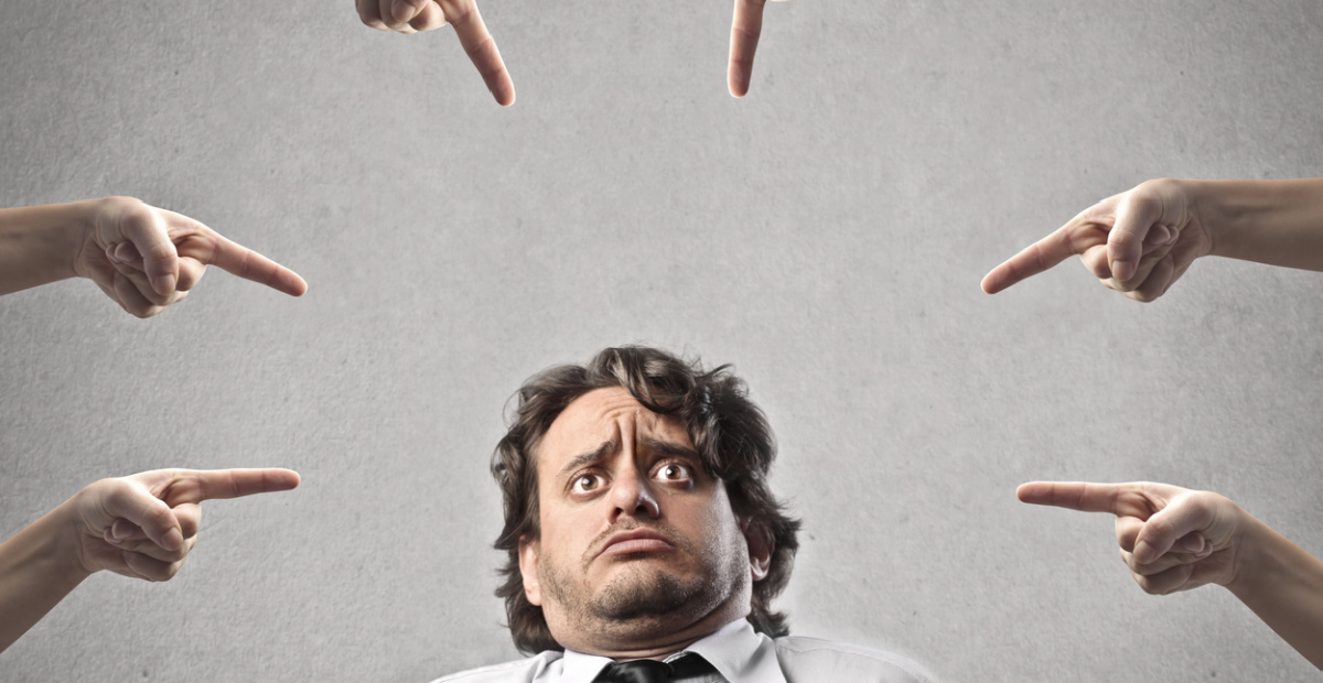 Accusing fingers point at man