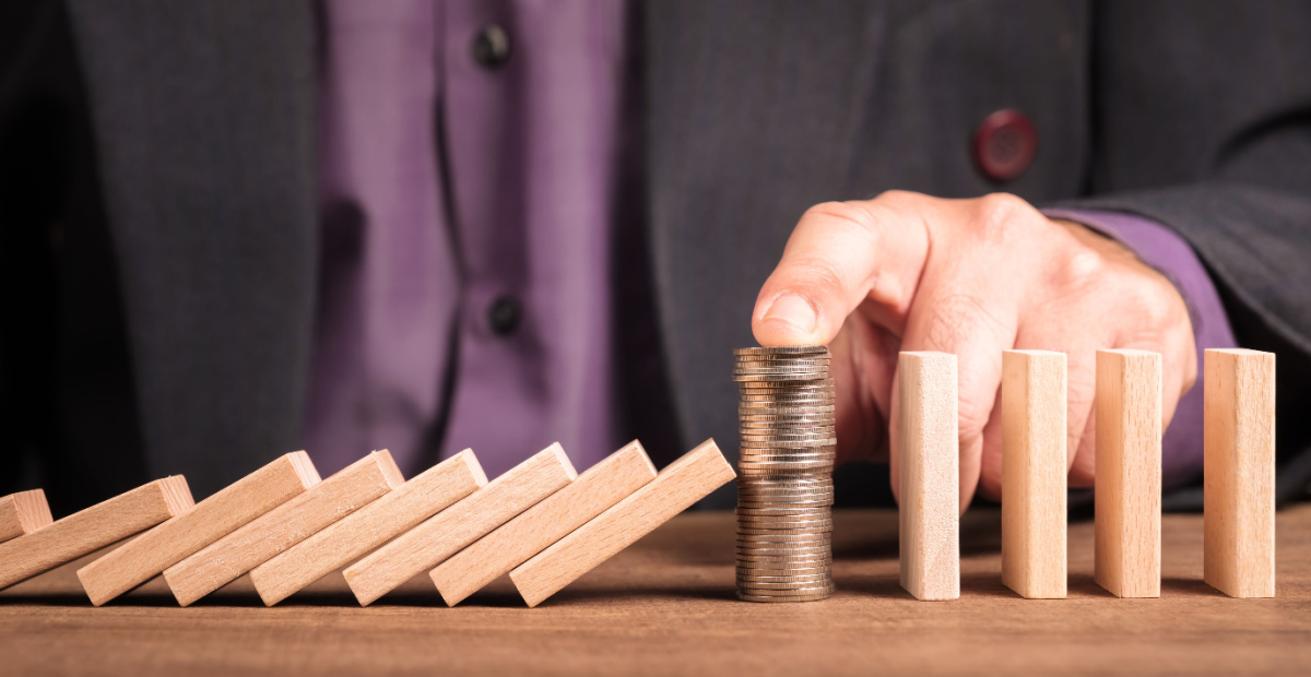 Man's finger protects coins from dominoes