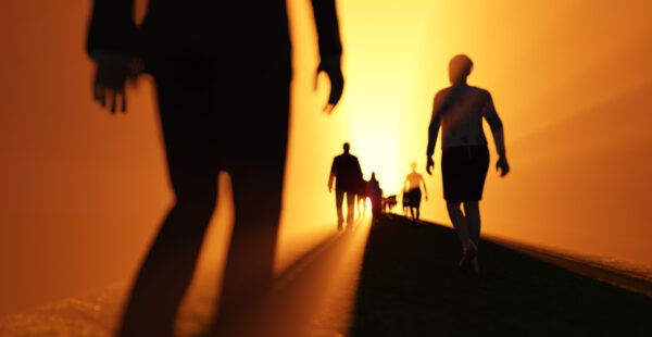 Figures walk down tunnel to light