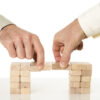 Two hands removing wooden blocks