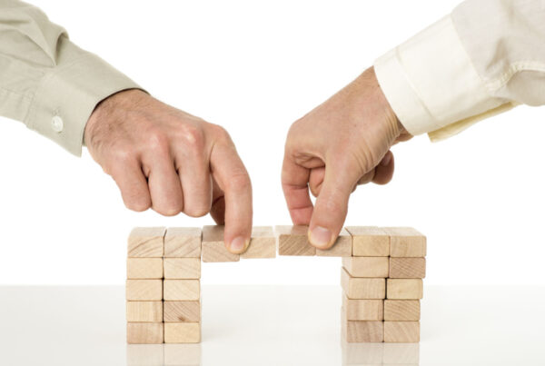 Two hands removing wooden blocks