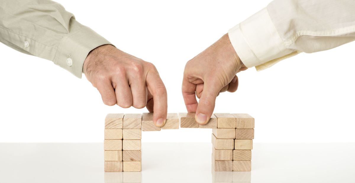 Two hands removing wooden blocks