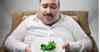Disappointed fat man with lettuce