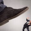 Large foot stepping on businessman