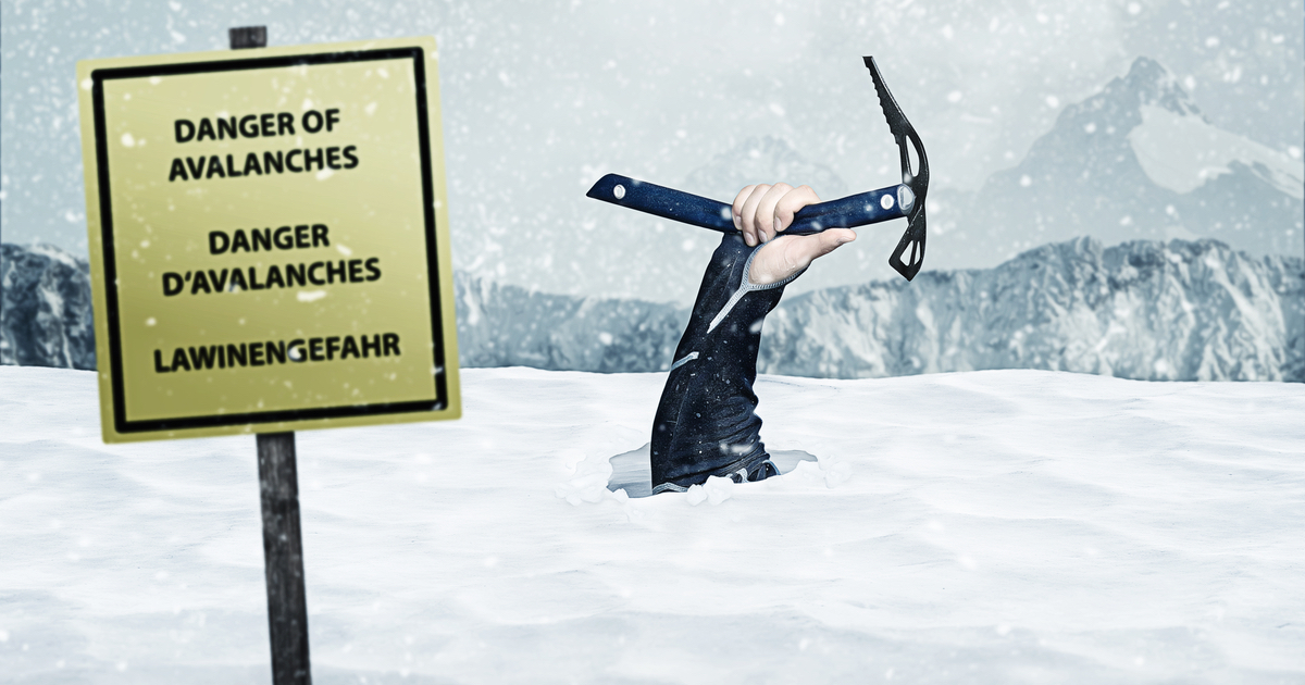Hand holding a snow pick with mountains and sign that says Danger of Avalanches