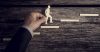 Man holding cut-out of man climbing steps